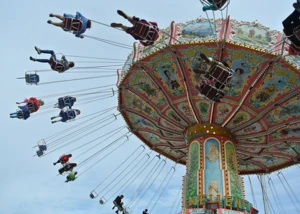 Blick nach oben auf Menschen in einem Kettenkarussell