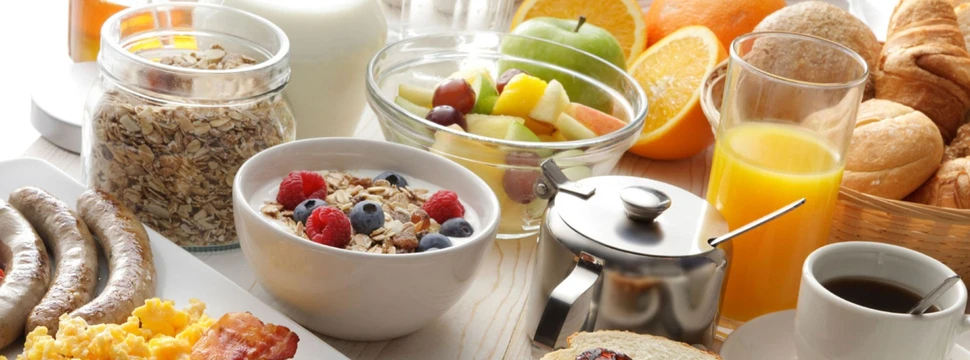 Frühstücksschälchen mit Obst, Müsli, Toast und Kaffee