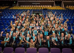 Viele Menschen sitzen mit unterschiedlichen Instrumenten auf einer Tribüne