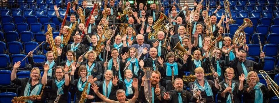 Viele Menschen sitzen mit unterschiedlichen Instrumenten auf einer Tribüne