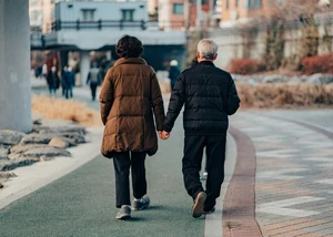 Ein Paar hält sich an den Händen und läuft durch eine belebte Straße