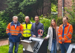Mehrere Menschen, die vor einem neuen Unterflurbehälter im Kieler Stadtteil Gaarden stehen, die für eine bessere Müllentsorgung sorgen sollen
