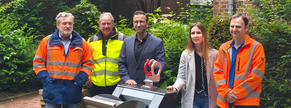 Mehrere Menschen, die vor einem neuen Unterflurbehälter im Kieler Stadtteil Gaarden stehen, die für eine bessere Müllentsorgung sorgen sollen