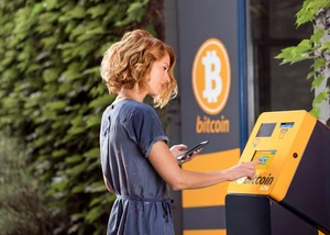 Eine Frau vor einem Bitcoin-Automaten Eine Frau vor einem Bankautomaten, der die Aufschrift "Bitcoin" trägt