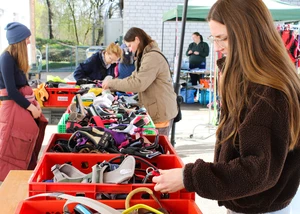 Menschen stöbern an einem Flohmarktstand mit Hunde Geschirren