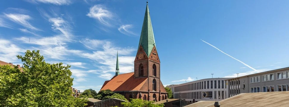 Eine Kirche in der Kieler Innenstadt mit dem blauen Himmel und einigen Wolken im Hintergrund