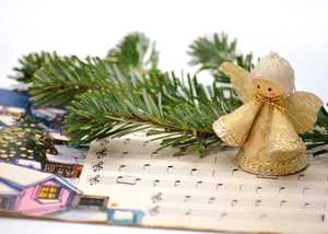 Weihnachtliche Deko auf einem Tisch, unter der sich Noten für ein Lied befinden