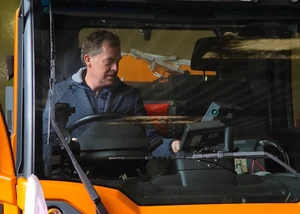 Ulf Kämpfer in einem Streufahrzeug des ABK-Kiels Der Kieler Oberbürgermeister hinter einer Glasscheibe in einem Streufahrzeug des ABK-Kiel im dortigen Betriebshof