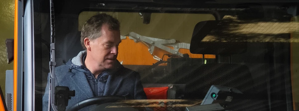 Der Kieler Oberbürgermeister hinter einer Glasscheibe in einem Streufahrzeug des ABK-Kiel im dortigen Betriebshof