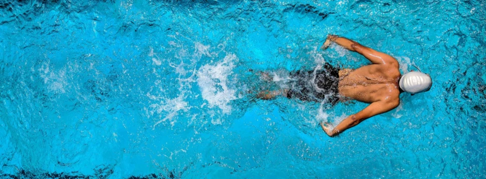 Ein Mann im Wasser beim Schwimmen in einem Schwimmbecken