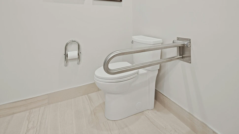 Eine Toilette mit einer Metallstange zum Festhalten