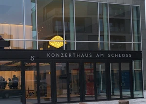 Ein gläserner Eingang eines Haus, an dem "Konzerthaus am Schloss" steht