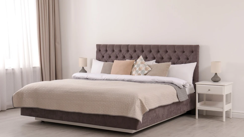 Polsterbett mit Kisssen und Überdecke in einem Schlafzimmer