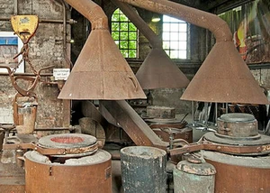 Innenansicht der Metallgießerei in Dietrichdorf mit Hochöfen und Vorrichtungen zum Bearbeiten des Metalls