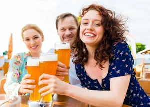 Im Biergarten kann man im Sommer perfekt den Abend ausklingen lassen Drei Erwachsene mit Bier