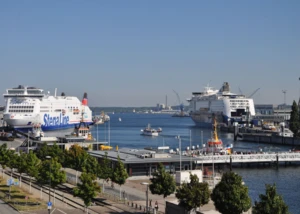 Fährschiffe im Hafen unter blauem Himmel. Hafen mit Fährschiffen von Stena Line und Color Line, umgeben von Wasser, kleinen Booten und Hafenanlagen.