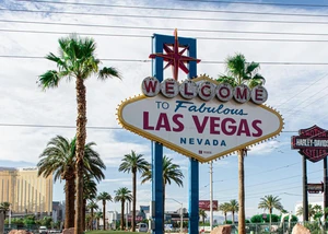 Ein Schild mit der Aufschrift "Welcome to Fabulous Las Vegas Nevada" zwischen Palmen
