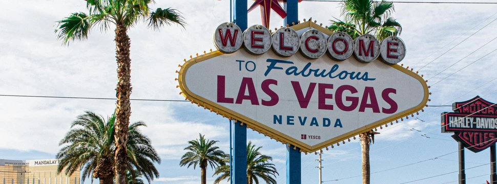 Ein Schild mit der Aufschrift "Welcome to Fabulous Las Vegas Nevada" zwischen Palmen
