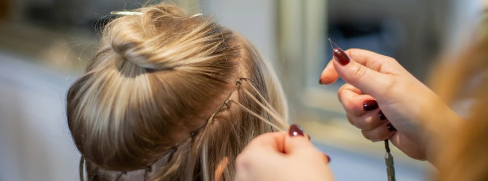 Frau lässt sich Extensions einflechten