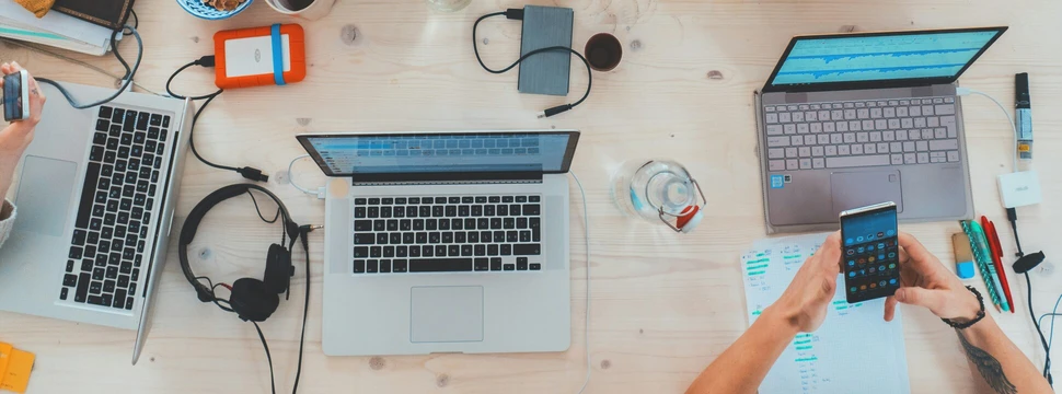 Auf einem Tisch liegen Laptops, Handys und Kabel