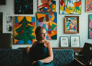 eine Frau sitzt in einem kunstvoll eingerichteten Wohnzimmer