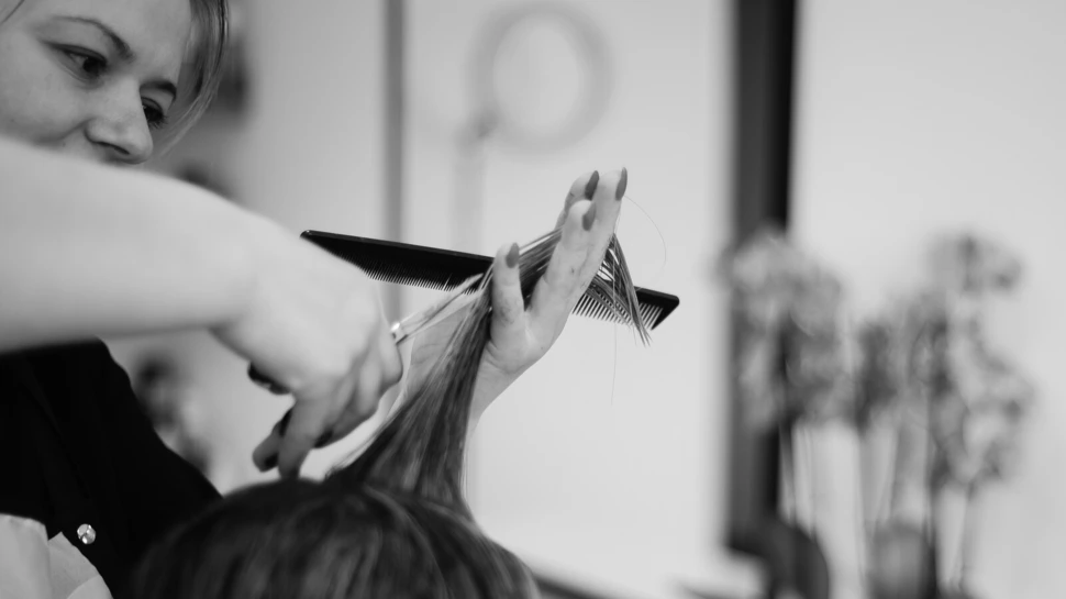 Frau schneidet einer anderen Frau die Spitzen