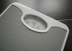 auf einer grauen Waage wir die Zahl 114 kg angezeigt