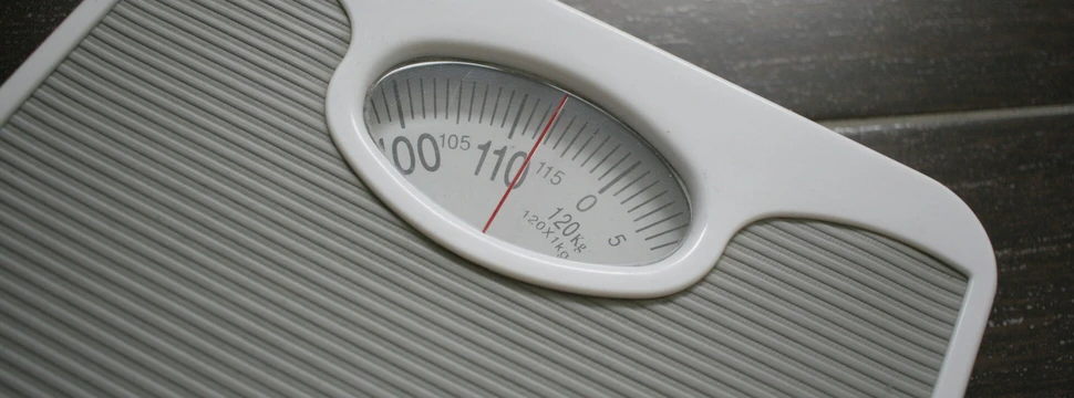 auf einer grauen Waage wir die Zahl 114 kg angezeigt