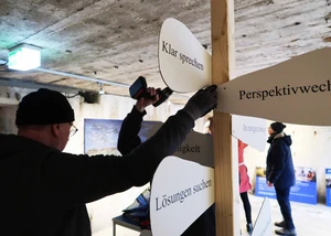 Mehrere Menschen, die in einem ehemaligen Bunker in Kiel an einer Ausstellungseröffnung arbeiten