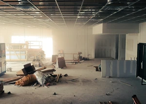 Baustelle von innen: Es liegen Holsreste, Schutt und Müll auf dem Boden