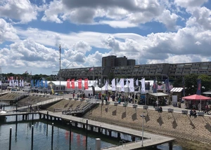 Die Kieler Woche erlebt man am allerbesten gemeinsam Hafen mit Zelten und vielen Fahnen, im Hintergrund ein Olympiahotel