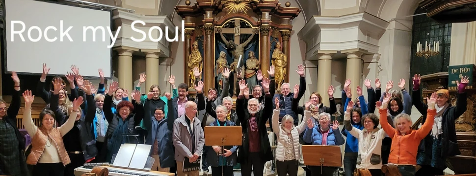 eine Menschengruppe steht in einer Kirche und hebt die Hände in die Luft