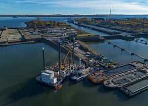 Ein Schiff vor einer Schleuse mit Containern im Hintergrund