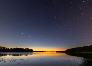 Der Westensee bei Nacht Aussicht über den Westensee am Abend mit der untergehenden Sonne und Sternen im Hintergrund