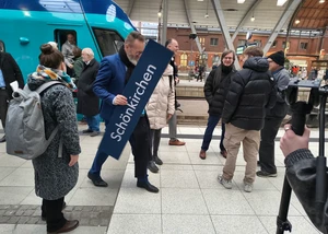 Der Wirtschaftsminister von Schleswig-Holstein mit einem Schild in der Hand, auf dem "Schönkirchen" steht
