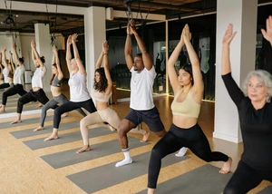 Teilnahme an einem Yoga-Kurs Teilnehmerinnen und Teilnehmer bei einem Yoga-Kurs während einer Übung