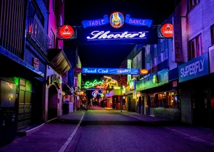 Verschiedene Leuchtreklamen hängen in einer Gasse