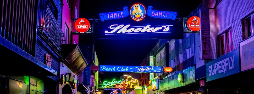 Verschiedene Leuchtreklamen hängen in einer Gasse