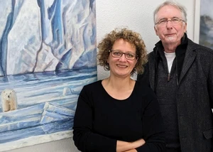 Eine Frau und ein Mann stehen rechte neben einem Gemälde