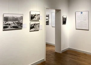 Museumsraum mit historischen Schwarz-Weiß-Fotografien an weißen Wänden und Parkett.