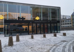 Ein gläserner Eingang eines Haus, an dem "Konzerthaus am Schloss" steht