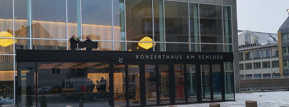 Ein gläserner Eingang eines Haus, an dem "Konzerthaus am Schloss" steht