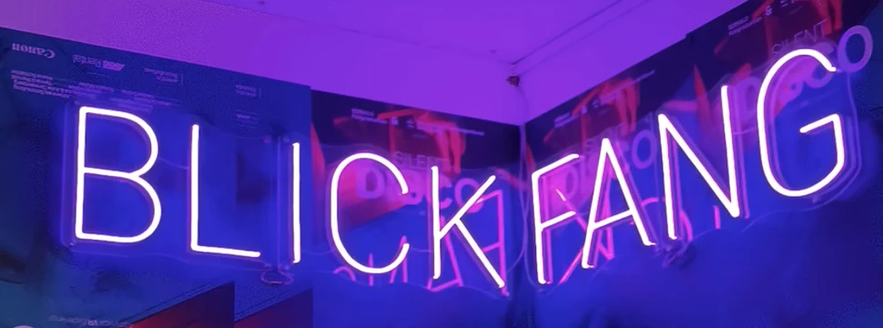 Ein Schild mit leuchtenden Buchstaben, die das Wort "Blickfang" bilden, an einer Wand