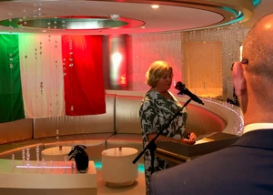 Frau am Mikrofon über eine Schulter fotografiert, italienische Flagge