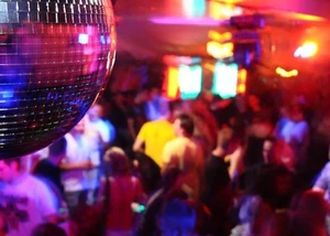 Gefüllte Tanzfläche, im Fokus sieht man eine Discokugel