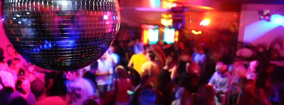 Gefüllte Tanzfläche, im Fokus sieht man eine Discokugel