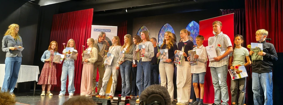Britta Poggensee mit allen Lesenden auf der Bühne, die am Landesfinale teilgenommen haben