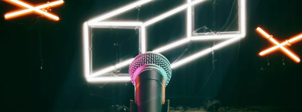 Mikrofon steht vor einer schwarzen Wand, wo in LED ein Quader abgebildet wird