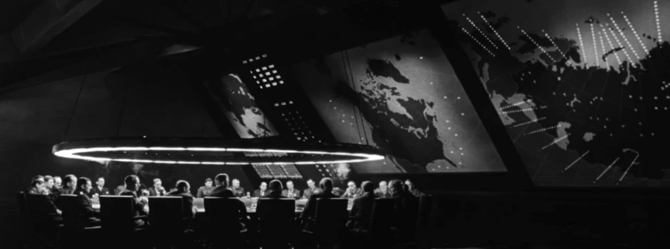 Eine Konferenz, bei der mehrere Menschen an einem Tisch sitzen und diskutieren. Das Bild ist in Schwarz-Weiß gehalten