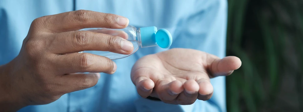 Person hält Desinfektionstube in der Hand